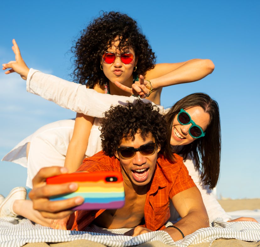 Group of friends taking a selfie on the beach after applying to Marriot Bonvoy's TikTok corresponden...