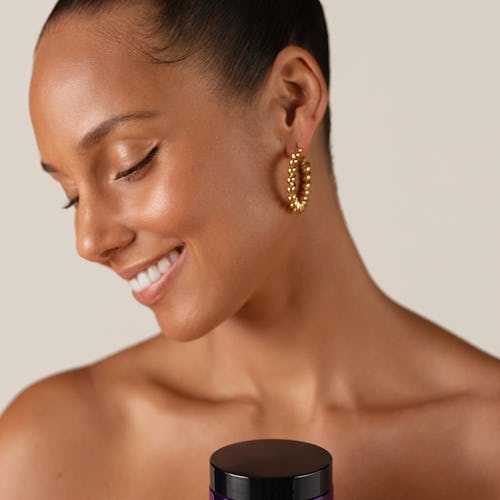 Alicia Keys holding the Nourishing Cleansing Balm from her Keys Soulcare skincare line