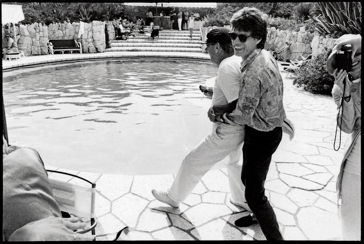 Mick Jagger attempting to push Helmut Newton into the pool.