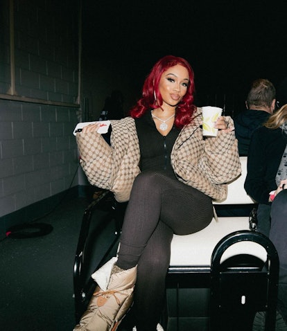 Saweetie with red hair on back on golfcart