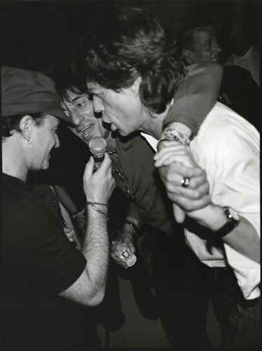 Bono, Ron Wood, and Mick Jagger at a party.