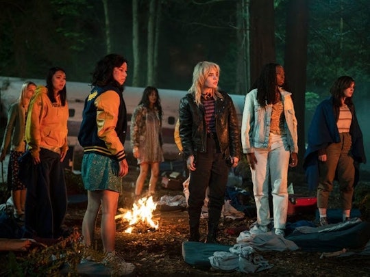 A scene from Yellowjackets with the cast around a camp fire 