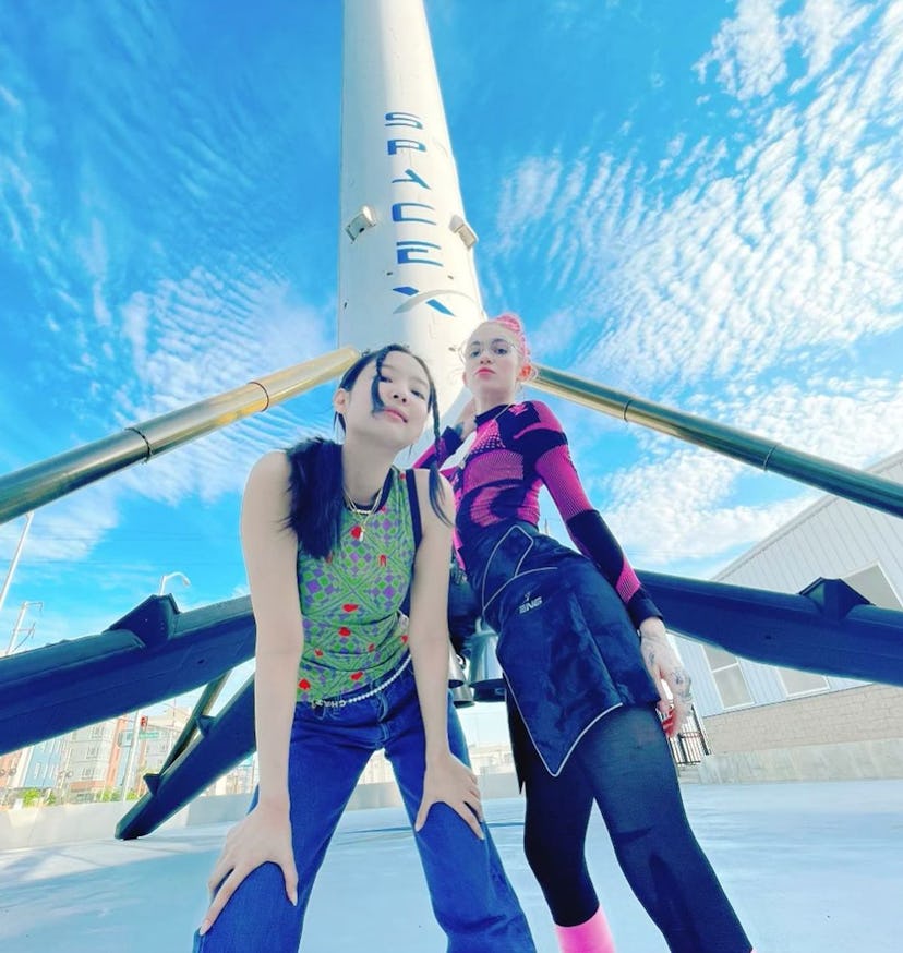 Jennie and Grimes posing in front of a rocket
