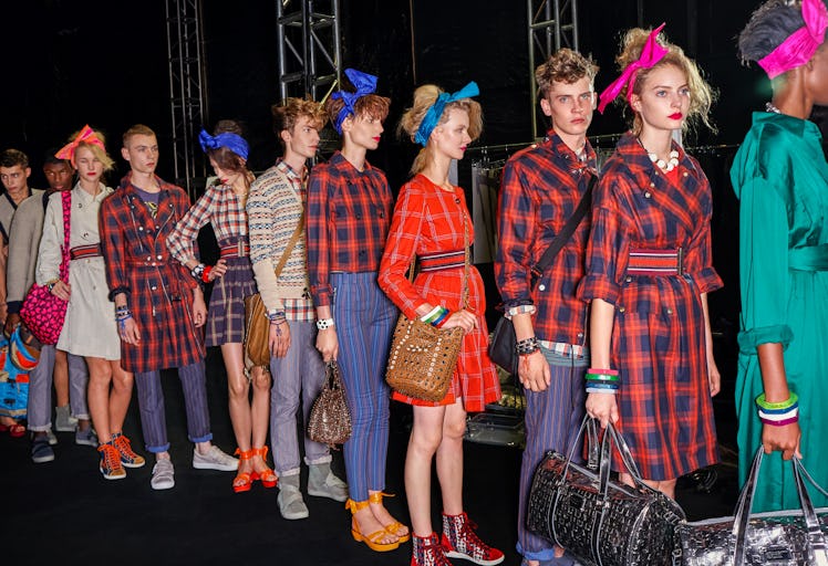 models in tartan lining up backstage at a fashion show