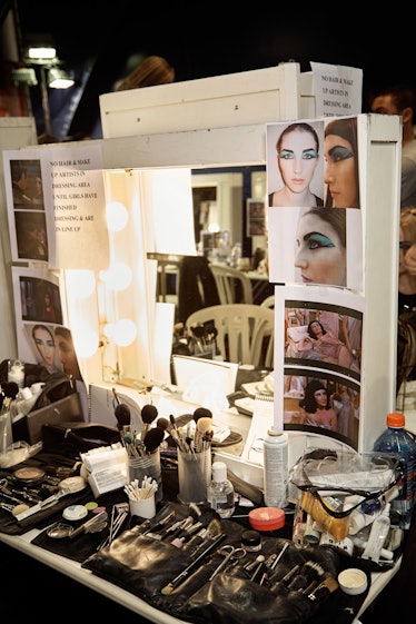 a makeup artist's station covered in reference photos