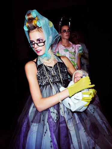 the model Jacquetta Wheeler wearing a look by John Galliano for Dior and holding a tiny baby