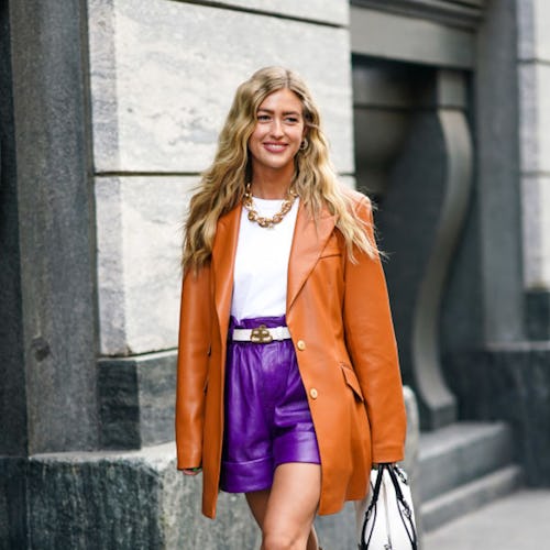 Emili Sindlev wears a tan leather blazer and leather shorts with boots