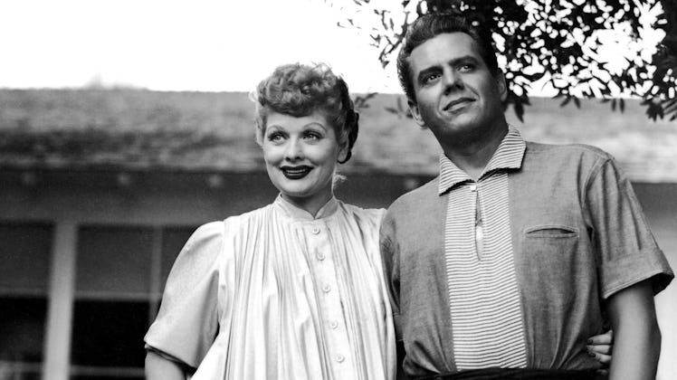 Lucille Ball and Desi Arnaz standing next to each other in front of a house and a tree from the docu...
