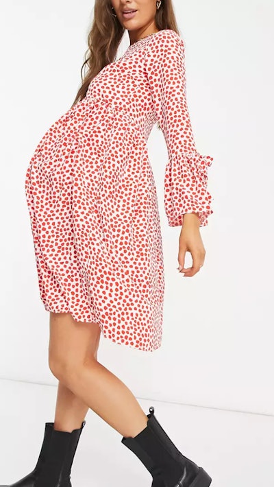 Pregnant woman modeling dress with red dots