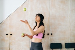 A woman juggles tennis balls. These fun skills to learn will impress anyone at a party.