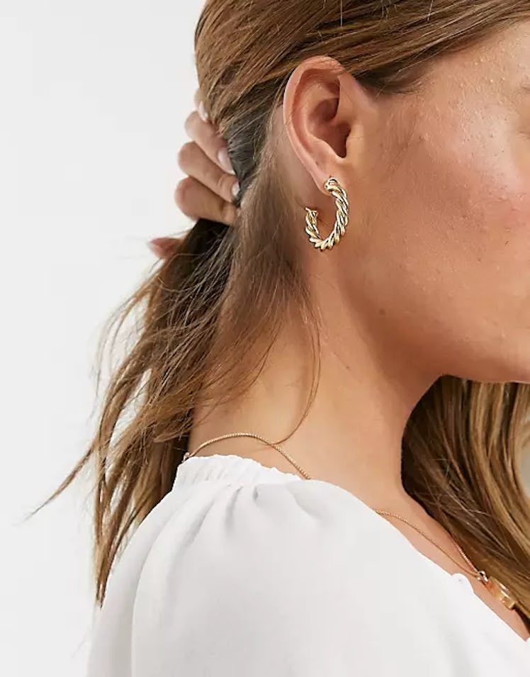 ASOS Design gold twist hoop earrings.