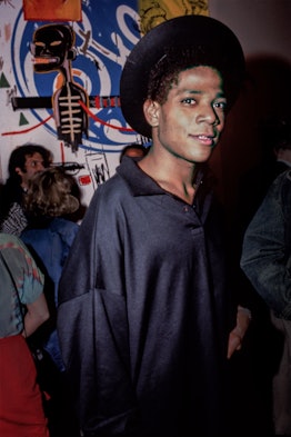 Jean-Michel Basquiat in front of one of his paintings