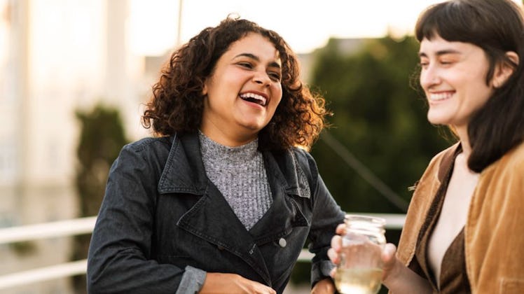 two women standing and laughing with each other