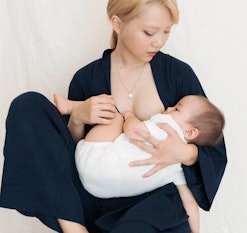 A mom nurses her baby in Storq pajamas