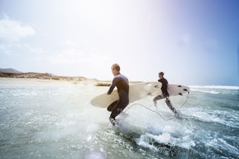 two men running through the surf