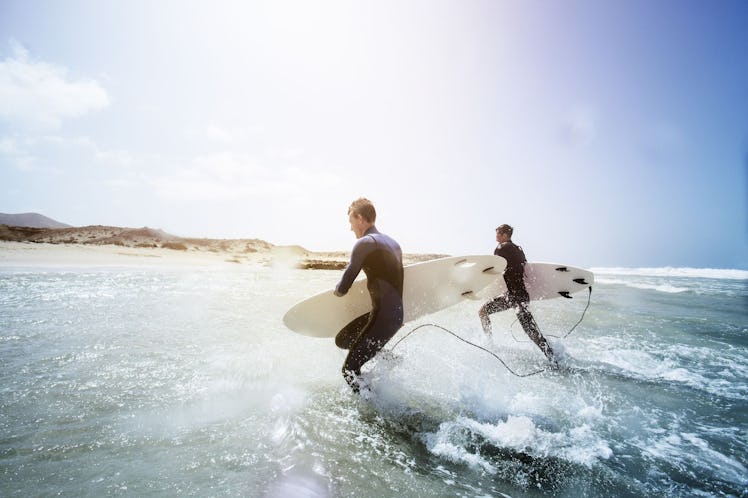 two men running through the surf