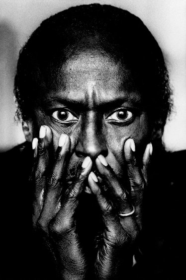 Miles Davis holding his hands up to his face