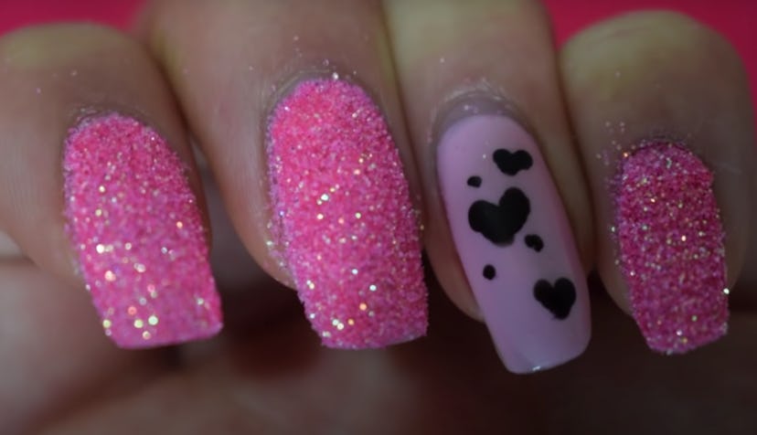 Close up of Valentine's Day nail art; pink glittery nails and hearts