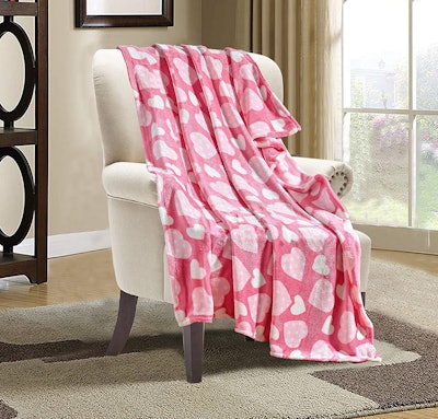 Pink blanket with white hearts draped over chair