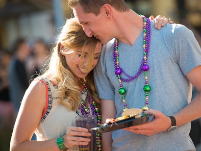 A couple enjoys Universal Orlando's Mardi Gras 2022 treats. 