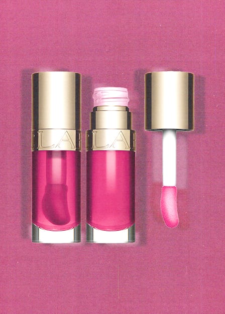 Two tubes of the Clarins Lip Comfort Oil l in pink with a pink background