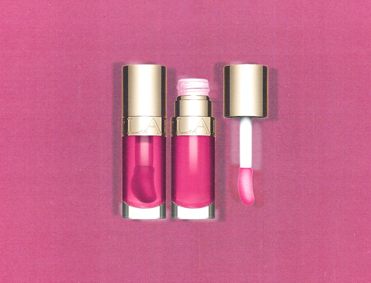 Two tubes of the Clarins Lip Comfort Oil l in pink with a pink background