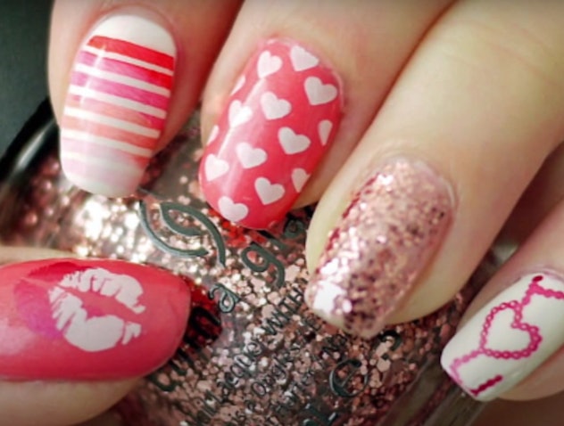 Up close photo of Valentine's Day manicure; kisses, stripes, hearts, and glitter polishes