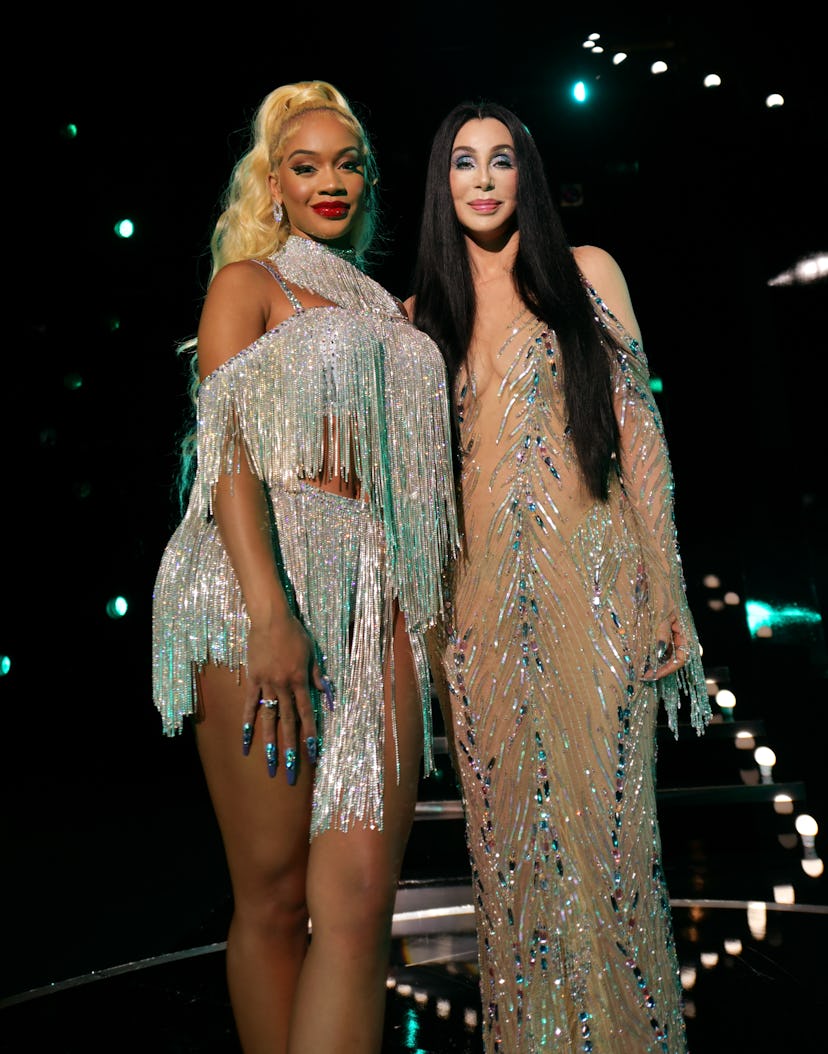 Cher and Saweetie posing for a photo in onstage costumes