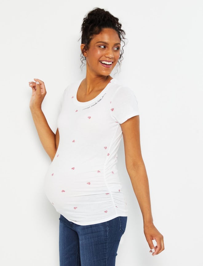 Pregnant woman modeling white tee shirt with red hearts