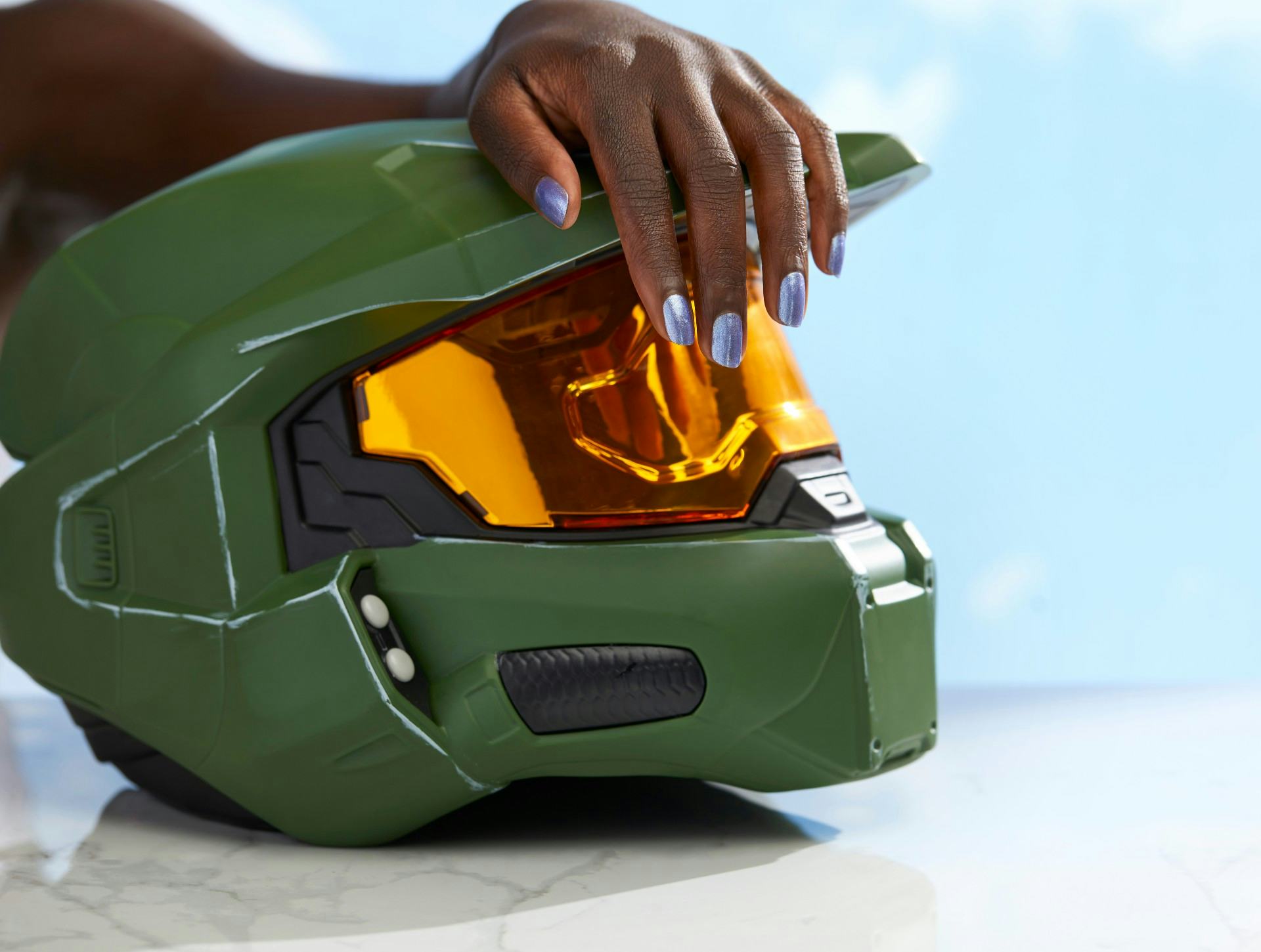 image of hand with blue nail polish on Master Chief helmet