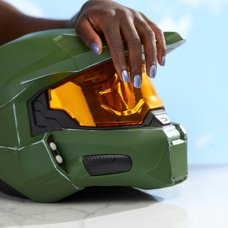 image of hand with blue nail polish on Master Chief helmet