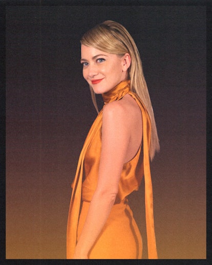 Meredith Hagner side profile photo, wearing an orange gold dress