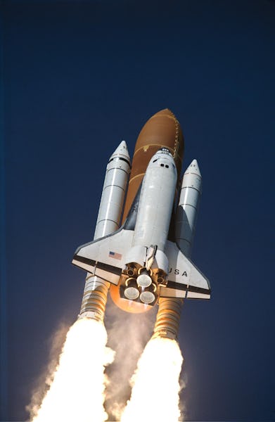 The space shuttle with its three main engines shooting off into space