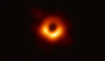 Hazy photo of black hole M87. This is the first ever photo taken of a black hole. The center is dark...