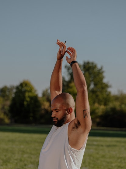 Lanardo Tyner, an American boxer, stretching his arms out on a green grass field. 