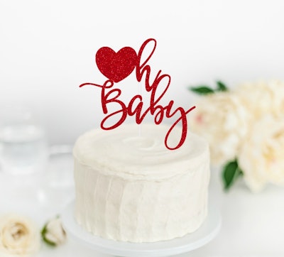 White cake with "Oh baby" topper
