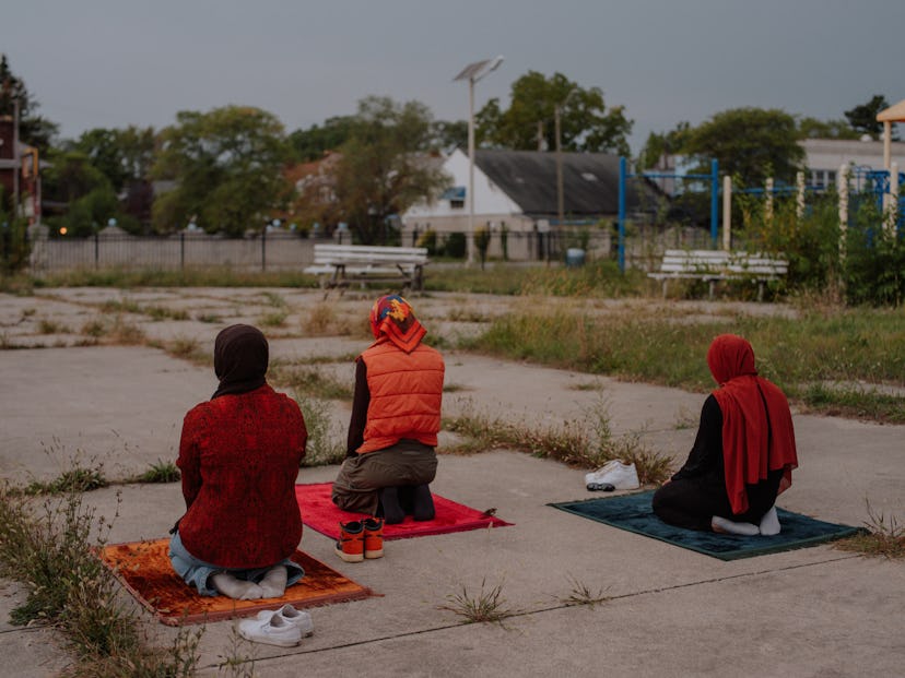 Three Muslim girls doing their daily prayer, outside. 