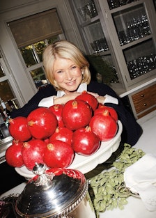 Martha Stewart standing behind a bowl of pomegranates