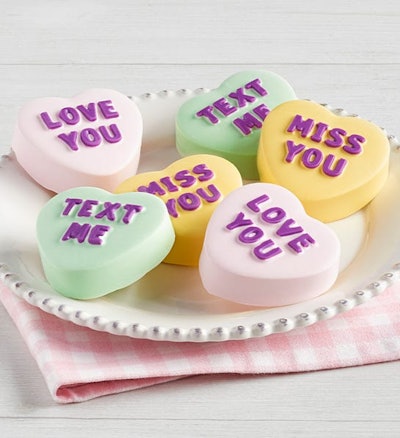 Plate of dipped oreos decorated to look like conversation hearts