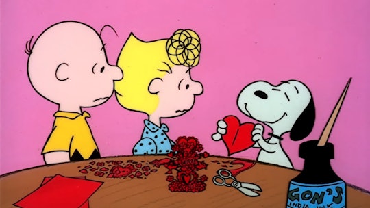 Charlie and Sally Brown look on as Snoopy displays a valentine he's made.