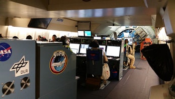 Color photo of several rows of computer consoles in a 747 cabin.