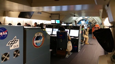 Color photo of several rows of computer consoles in a 747 cabin.