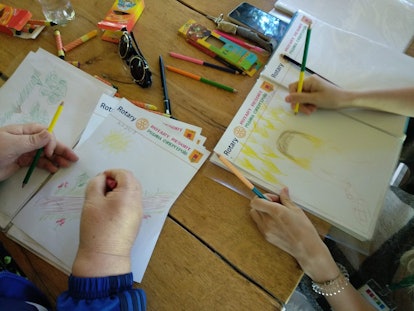 Two Ukrainians drawing in notebooks in the 'Superhero Therapy'