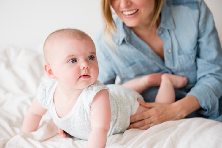 A mom helps a baby have tummy time.