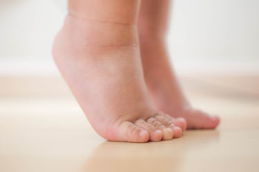 Close up of the feet of a toddler toe walking.