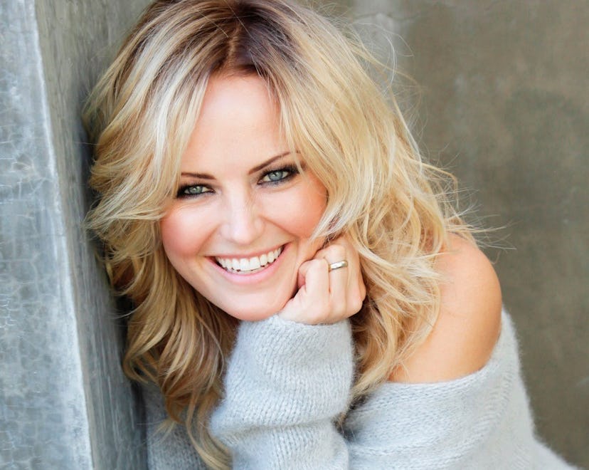 Malin Akerman posing for a picture in a light blue jumper