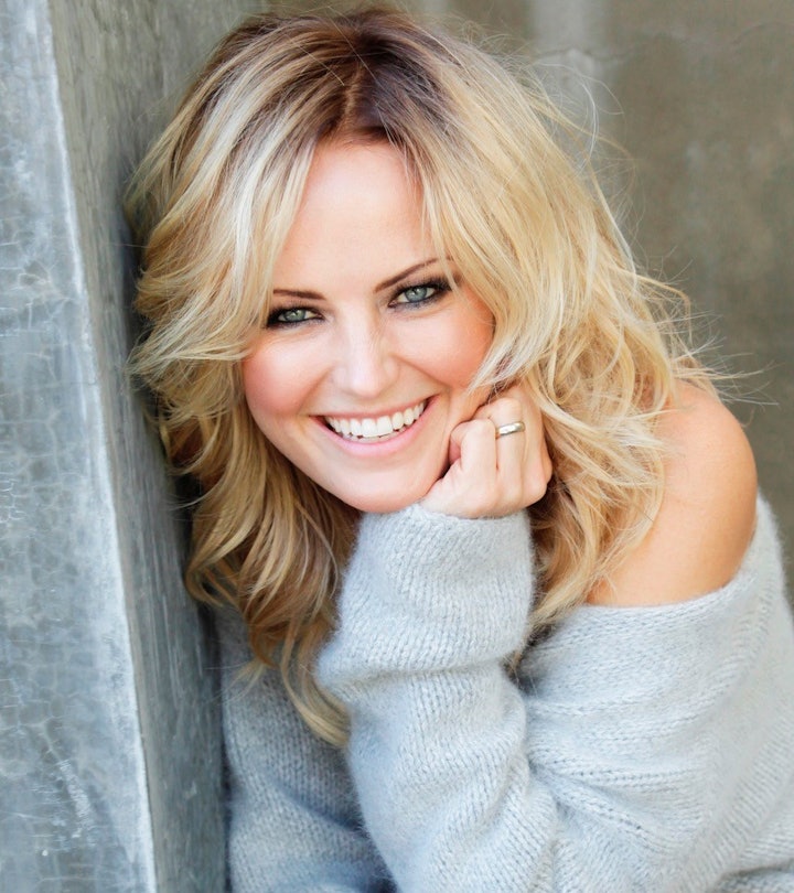 Malin Akerman posing for a picture in a light blue jumper