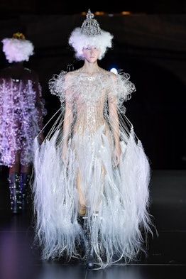 A model wearing a white dress with feathers and translucent elements by Noir Kei Ninomiya