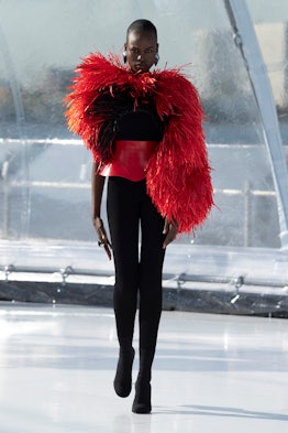 A model in a red-black jumpsuit with feathers at the Alexander McQueen spring 2023 fashion show