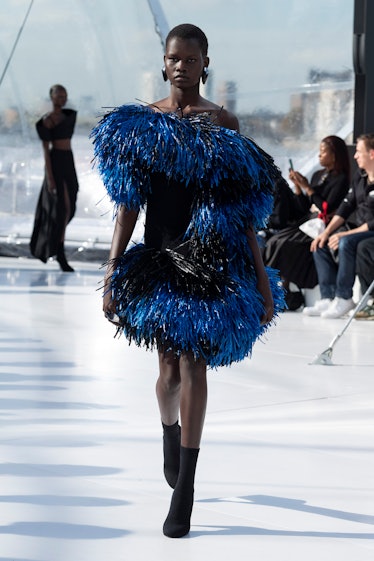 A female model walking in a blue faux fur dress at the Alexander Mcqueen runway spring 2023